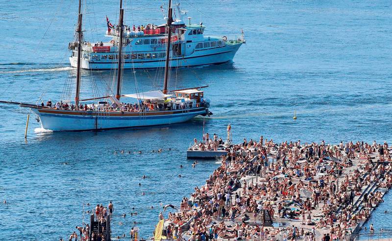 Boats sail past the crowded bathing area at Sorenga in Oslo at the Norwegian capital's inner harbor pool. Weather forecasters predict new temperature highs across western Europe hit by another heatwave setting new temperature records. AFP