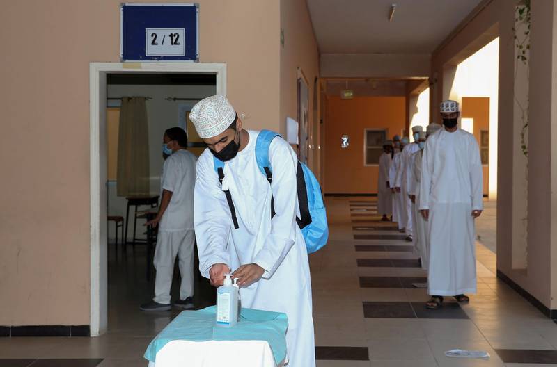 Omani students wait in line to disinfect their hands before class amid the COVID-19 pandemic, on the first day of the new academic year at Imam Jaber Bin Zaid secondary school in the capital Muscat, on November 1, 2020. / AFP / MOHAMMED MAHJOUB
