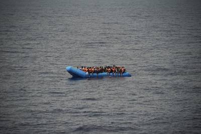 FILE - In this Sept. 17, 2019, file photo, migrants aboard a blue plastic boat are seen in the Mediterranean Sea. The U.N. refugee agency is investigating why Malta last week allegedly asked the Libyan coast guard to intercept a migrant boat in a zone of the Mediterranean under Maltese responsibility, in possible violation of maritime law, a U.N. official said Tuesday, Oct. 22, 2019. (AP Photo/Renata Brito)