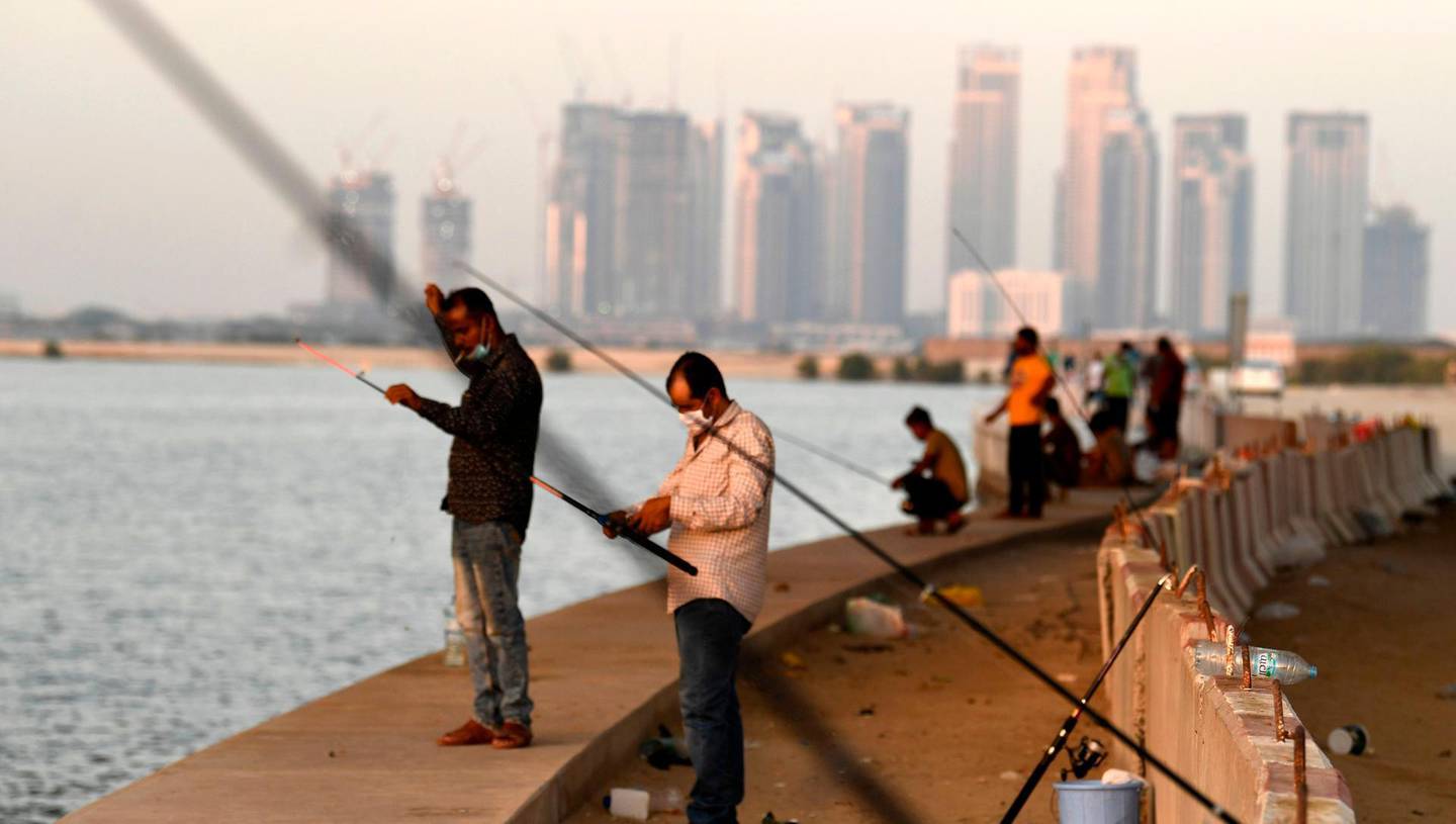 Men gather to fish at the creek in the Gulf city of Dubai, after the Emirati authorities eased some of the restrictions that were put in place in a bid to stem the spread of the novel coronavirus, on May 27, 2020.  The Emirati 
  / AFP / Karim SAHIB

