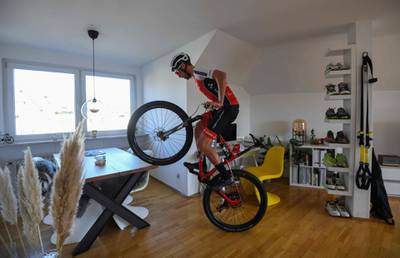 Ben Zwiehoff, the German national team's racing cyclist in the mountain bike cross-country discipline works on his balance on his bike in his flat, in Essen, western Germany.  AFP
