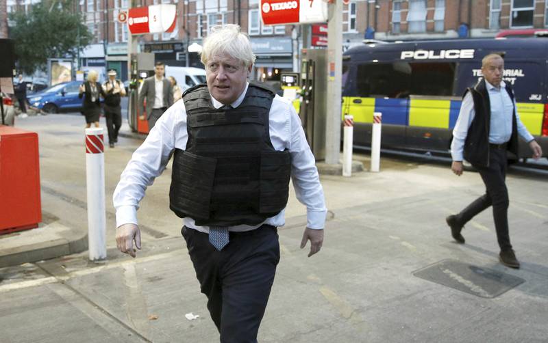 Mr Johnson leaves the area following the raid in West Norwood. AP