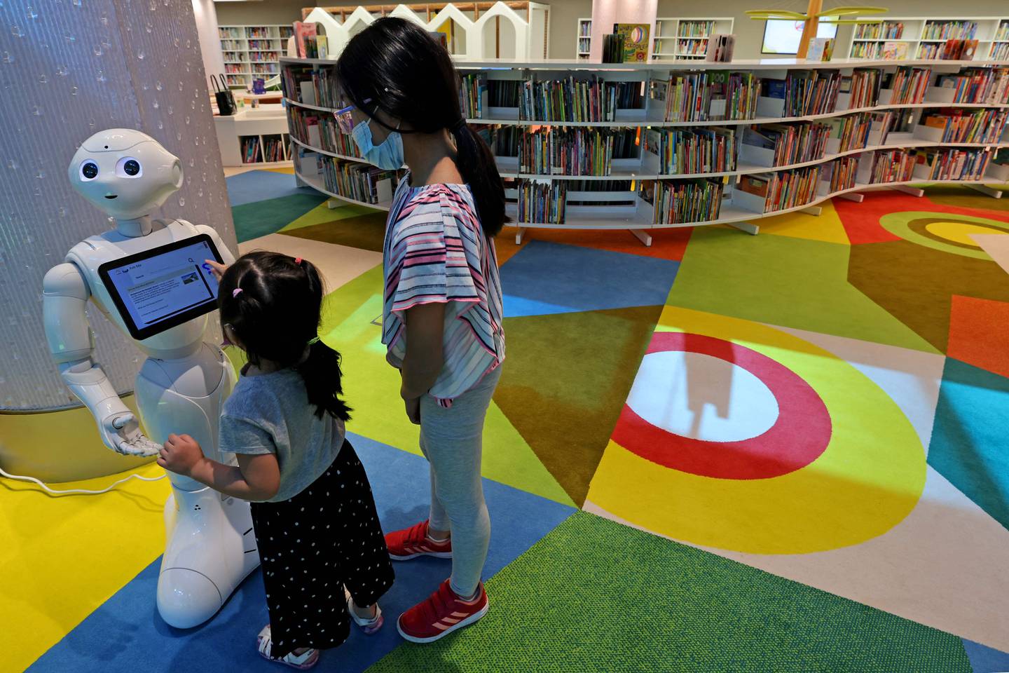 Children use a robot for assistance at the newly opened Mohammed bin Rashid Library in Dubai. AFP
