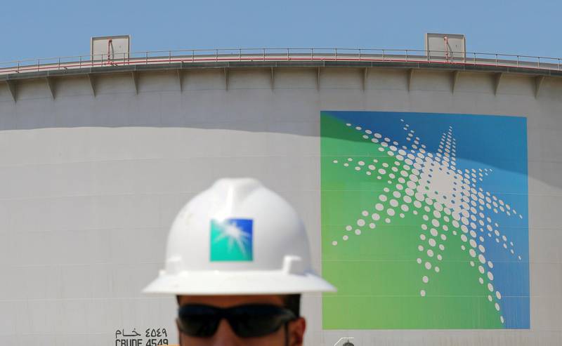 An Aramco employee walks near oil tank at Saudi Aramco's Ras Tanura oil refinery and oil terminal in Saudi Arabia May 21, 2018. Picture taken May 21, 2018. REUTERS/Ahmed Jadallah