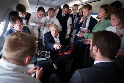 Mr Johnson talks to journalists on his plane during a flight from Germany – where he was attending the G7 summit – to the Nato summit in the Spanish capital. PA