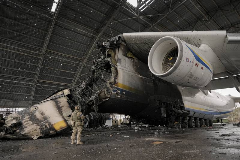 A Ukrainian soldier walks by the wreckage of the Antonov An-225 Mriya aircraft , the world's largest cargo airplane and relic of the Soviet space programme, which was destroyed during fighting in Hostomel, Ukraine. AP