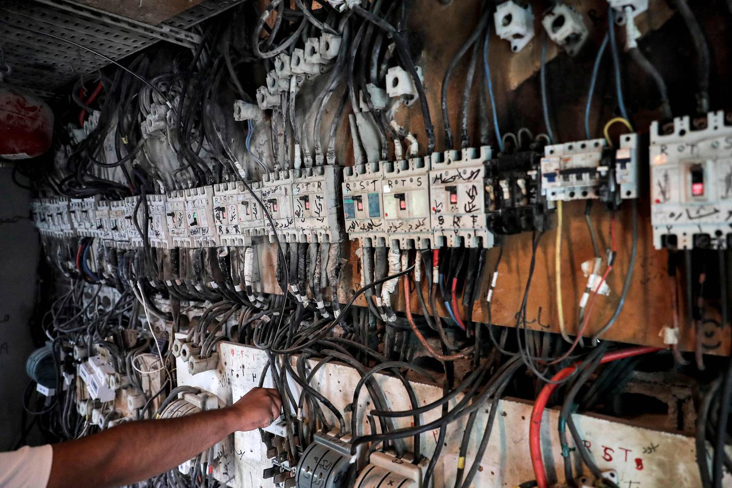 A technician controls an electric switchboard connecting homes to electricity generators in a suburb of Beirut, the capital of Lebanon.  AFP