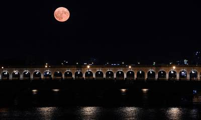The moon with the Pont de Bercy over the Seine in Paris. AFP