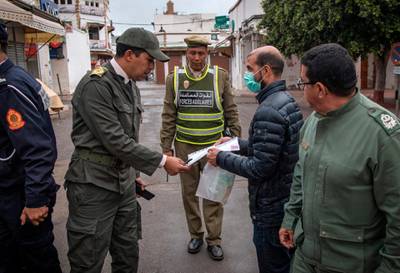Members of Morocco's Interior Ministry Auxiliary Forces instruct a man to return home in the capital Rabat, Morocco.  AFP