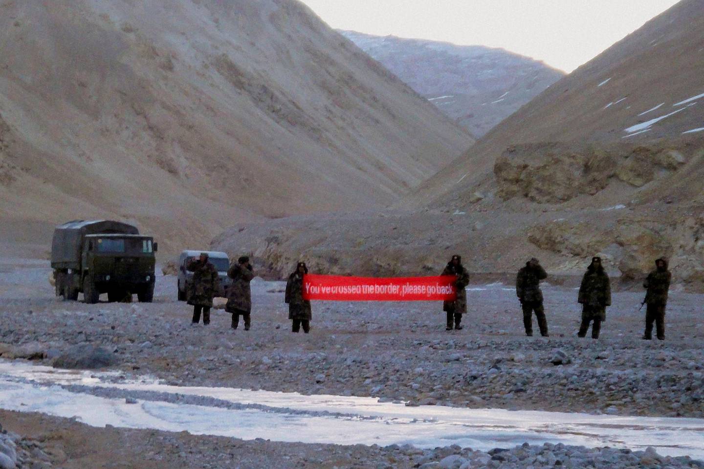 FILE - In this May 5, 2013, file photo, Chinese troops hold a banner which reads: "You've crossed the border, please go back" in Ladakh, India. China on Tuesday, June 16, 2020 accused Indian forces along their Himalayan border of carrying out "provocative attacks" on its troops, leading to "serious physical conflicts" between the sides. (AP Photo, File)