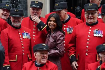 Akshata Murty, wife of Prime Minister Rishi Sunak, poses with a group of Chelsea Pensioners in Downing Street, London. PA