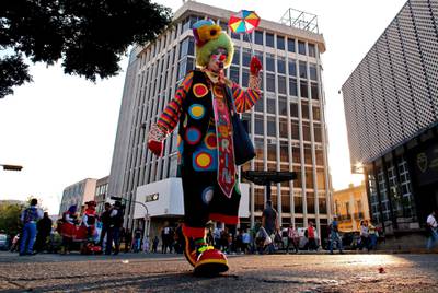 A clown walks down a street in Guadalajara. AFP