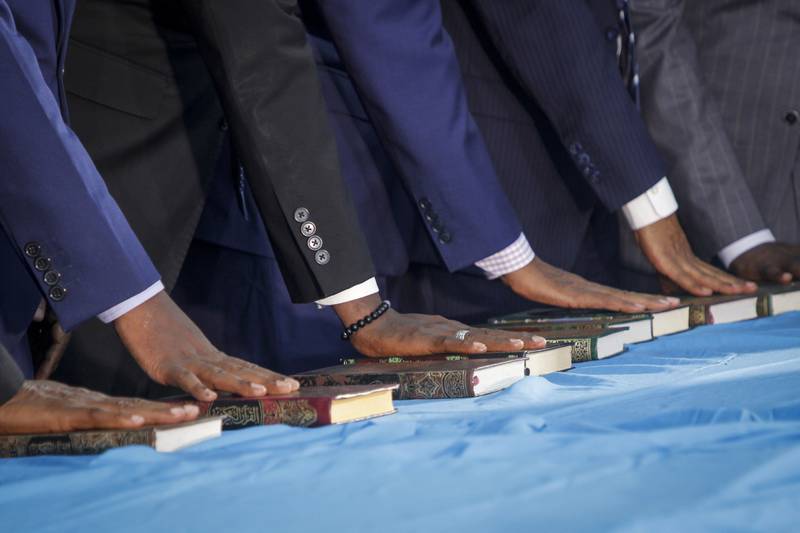 Somali politicians place their hands on copies of the Quran during the swearing-in ceremony on Thursday. AP