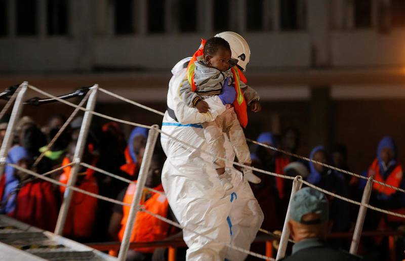 A rescuer carries a migrant child, intercepted off the coast in the Mediterranean Sea, after arriving on a rescue boat at the port of Malaga, southern Spain, October 19, 2018. REUTERS/Jon Nazca