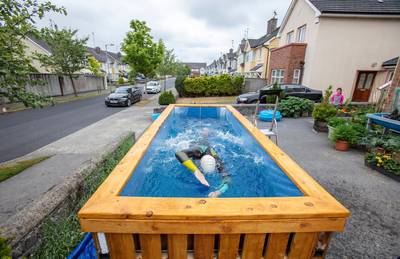 Irish Paralympic hopeful Leo Hynes, who is legally blind, trains in his home-made training pool in his front garden at home in Tuam, Co Galway, west Ireland, on June 18, 2020. - In his suburban driveway in the west of Ireland, blind triathlete Leo Hynes clambers into a box of water, straps himself to a bungee cord and starts to swim -- going nowhere, but going fast. During coronavirus lockdown, the aspiring paralympian has been unable to train as usual for the now-delayed Tokyo games. Instead he has been finessing his breaststroke in a homemade "treadmill pool" where he is held in place by elastic cords. (Photo by Paul Faith / AFP) / TO GO WITH AFP STORY BY JOE STENSON