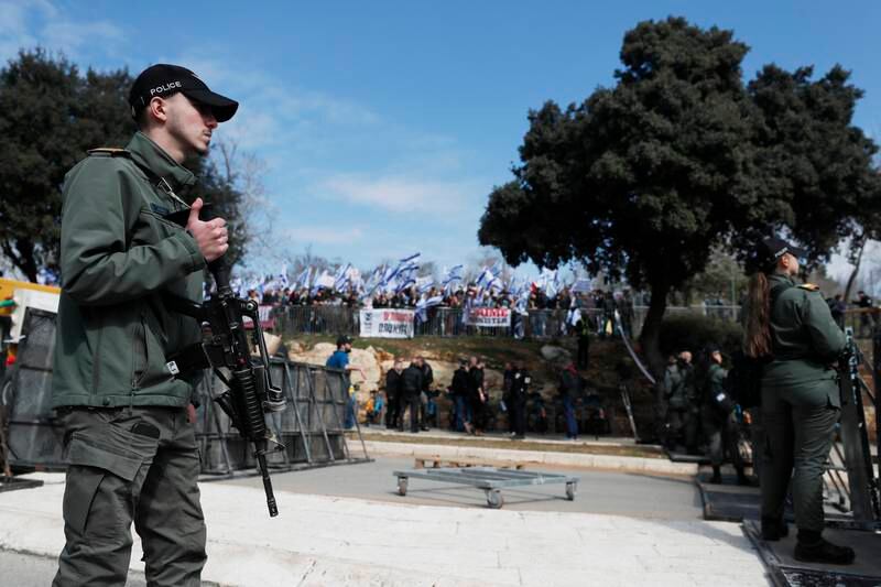 Armed police watch over protesters during an anti-government rally near the Israeli parliament in Jerusalem on Monday. EPA