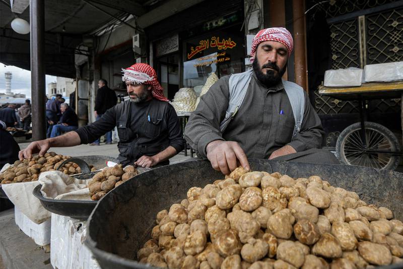 Stallholders sort their desert truffle stock at the market in Hama, west-central Syria