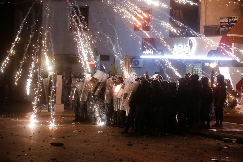 Fireworks are set off in front of police officers standing in postion behind riot shields during a protest at the Corniche al Mazzraa in Beirut, Lebanon. REUTERS