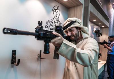 Abu Dhabi, U.A.E., February 20, 2019. INTERNATIONAL DEFENCE EXHIBITION AND CONFERENCE  2019 (IDEX) Day 4--  Colour images.-- A visitors at the show look at the Sultan assault rifle..Victor Besa/The NationalSection:  NA