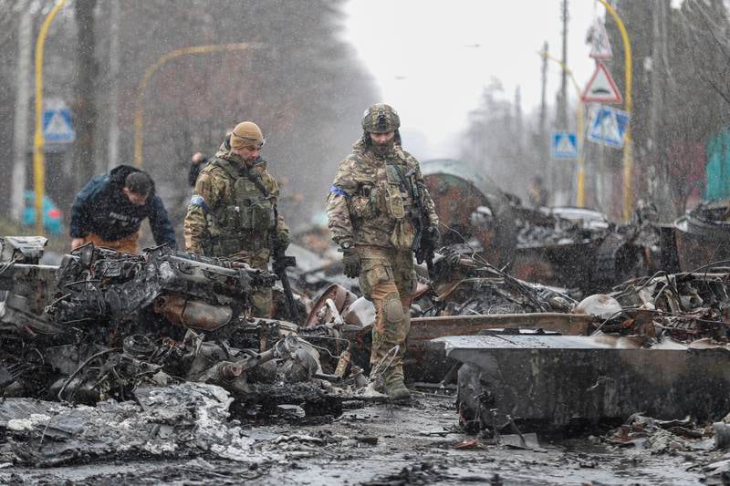 Ukrainian Soldiers inspect destroyed Russian vehicles in Bucha. EPA