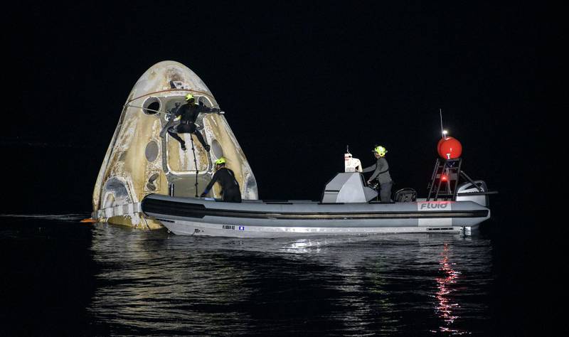 A support team work around the SpaceX Crew Dragon capsule shortly after it splashed down. AP Photo