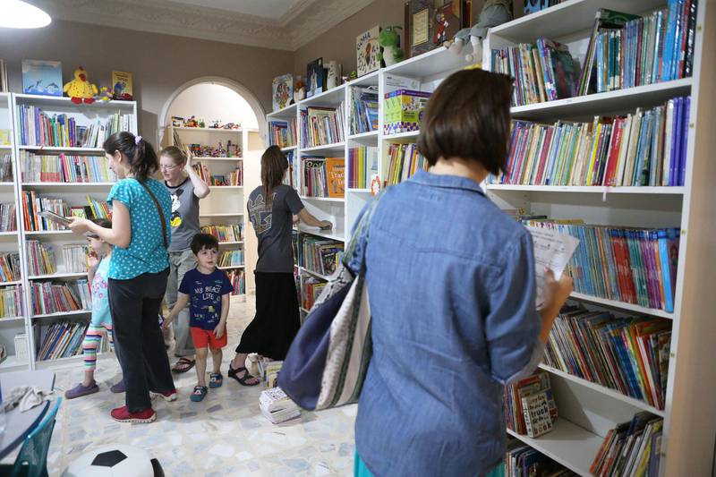 Visitors are seen at the library Books and More which is owned by American couple Nancy and Harvey, in Amman, Jordan. (Salah Malkawi for The National)