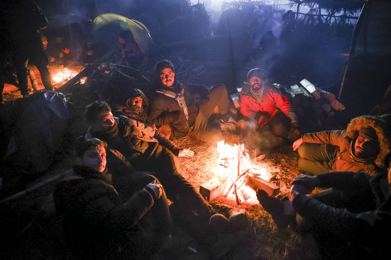 Migrants warm themselves near a fire in Grodno, Belarus. AP Photo
