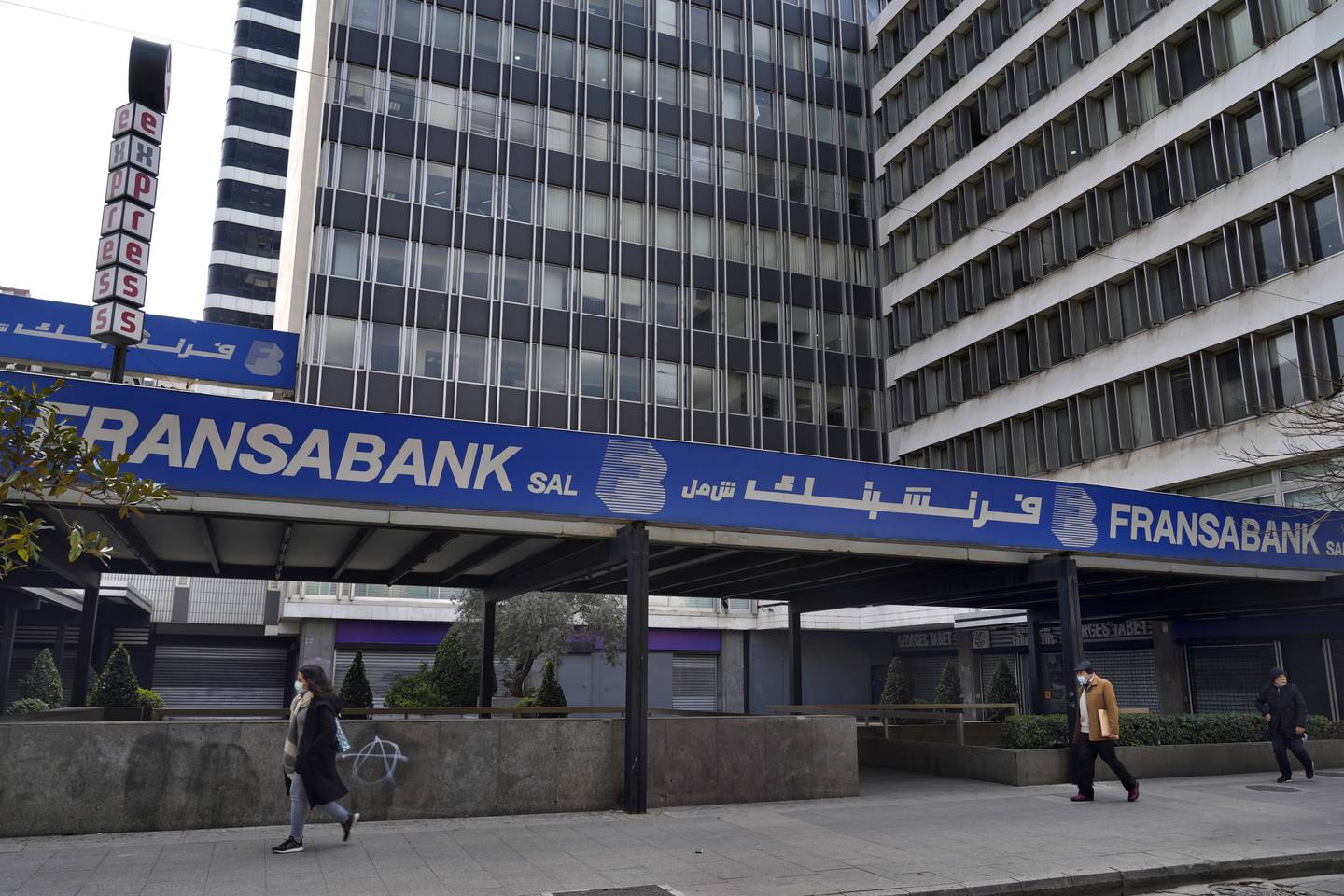 People walk past a closed Fransa Bank branch in Beirut. Photo: AP 