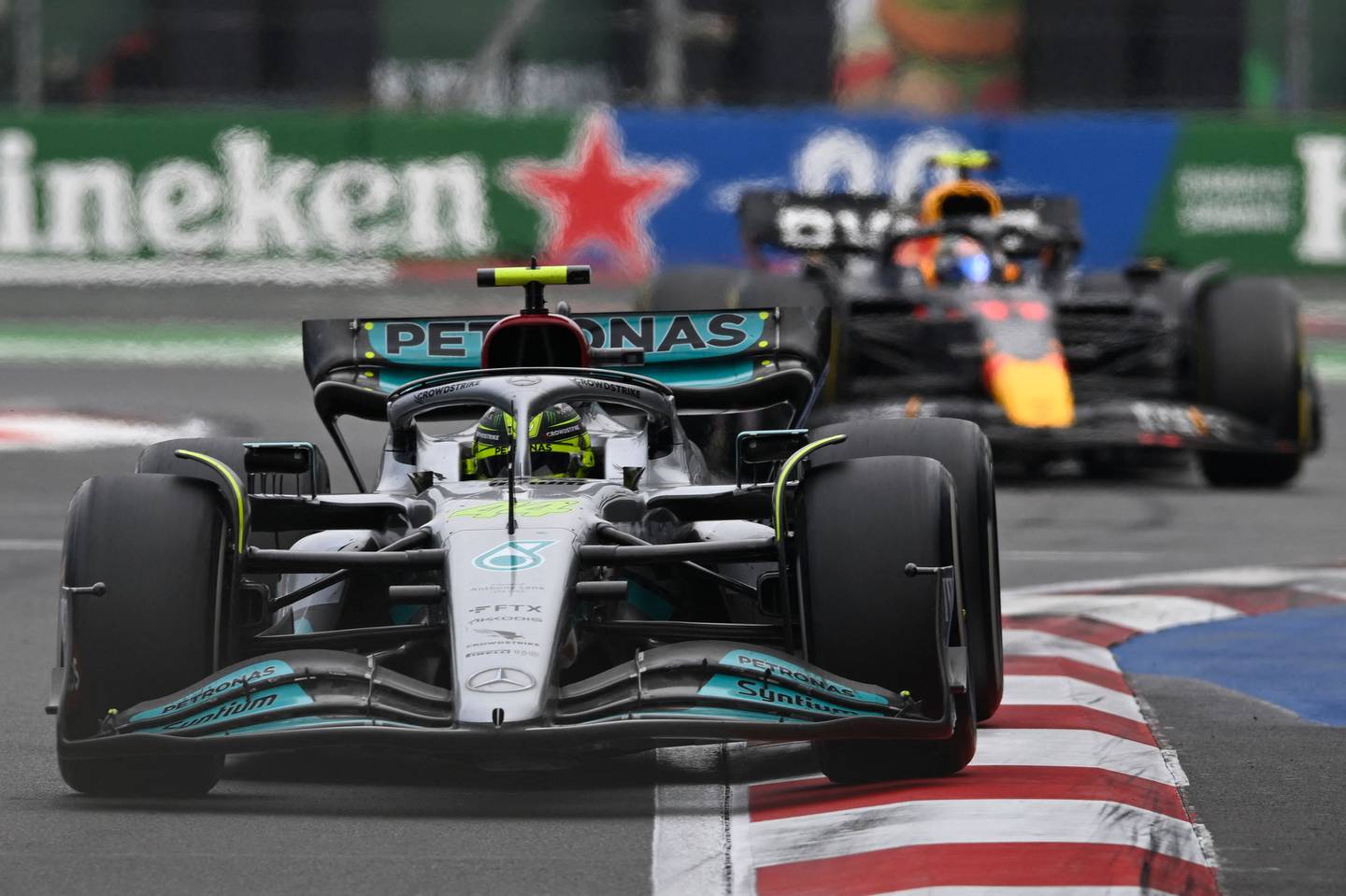 Le pilote britannique de Mercedes Lewis Hamilton court devant le pilote mexicain de Red Bull Racing Sergio Perez à Mexico dimanche.  AFP