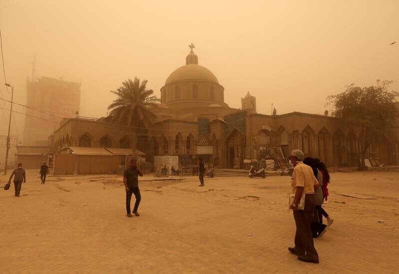 Iraqis walk along a street at the Shorja market shrouded in heavy dust in central Baghdad. EPA