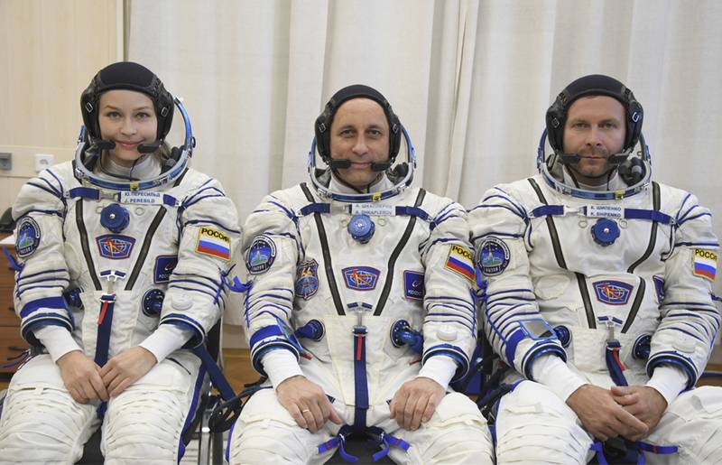 In this handout photo released by Roscosmos, Actress Yulia Peresild, left, director Klim Shipenko' right, and cosmonaut Anton Shkaplerov, members of the prime crew of Soyuz MS-19 spaceship pose at the Russian launch facility in the Baikonur Cosmodrome, Kazakhstan, Sunday, Sept.  19, 2021.  In a historic first, Russia is set to launch an actress and a film director to space to make a feature film in orbit.  Actress Yulia Peresild and director Klim Shipenko are set to blast off Tuesday for the International Space Station in a Russian Soyuz spacecraft together with Anton Shkaplerov, a veteran of three space missions.  (Roscosmos Space Agency via AP)