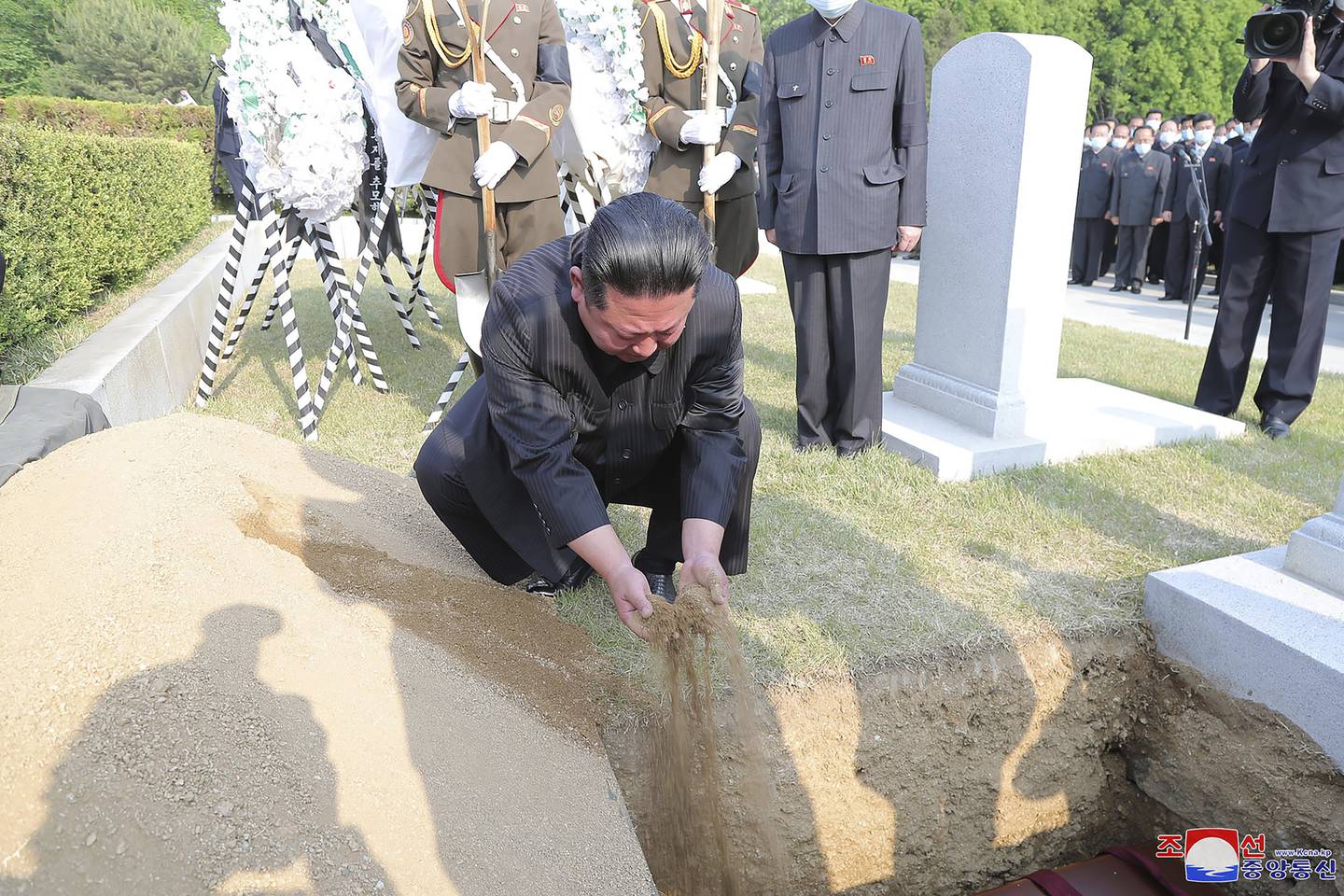 Kim Jong-un covers the coffin of Marshal of the Korean People's Army Hyon Chol-hae with earth at a cemetery in Pyongyang. Korean Central News Agency/AP