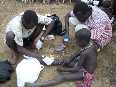 A health worker extracts a worm from a child's leg as Samuel Makoy Yibi, the national co-ordinator for the Guinea Worm Eradication Programme in South Sudan, assists.