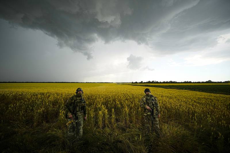 Russian soldiers guard an area next to a field of wheat in the Zaporizhzhia region. AP 