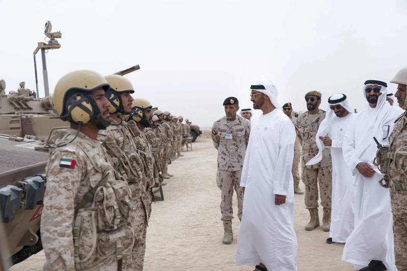 AL DHAFRA REGION, ABU DHABI, UNITED ARAB EMIRATES - April 08, 2018: HH Sheikh Mohamed bin Zayed Al Nahyan Crown Prince of Abu Dhabi Deputy Supreme Commander of the UAE Armed Forces (5th R),   speaks with a member of the UAE Armed Forces, during a military exercise titled ‘Homat Al Watan 2 (Protectors of the Nation)’, at Al Hamra Camp. Seen with HH Major General Pilot Sheikh Ahmed bin Tahnoon bin Mohamed Al Nahyan, Chairman of the National and Reserve Service Authority (6th R), HE Staff Major General Juma Al Bowardi, Commander of the UAE Armed Forces Land Forces (4th R), HH Sheikh Nahyan Bin Zayed Al Nahyan, Chairman of the Board of Trustees of Zayed bin Sultan Al Nahyan Charitable and Humanitarian Foundation (3rd R) and HE Mohamed Ahmad Al Bowardi, UAE Minister of State for Defence Affairs (2nd R).

( Rashed Al Mansoori / Crown Prince Court - Abu Dhabi )
---