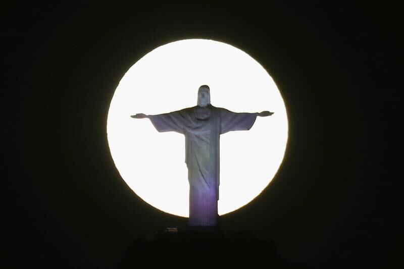 The supermoon, which causes the Moon to appear larger than usual, shines behind the Christ the Redeemer statue in Rio de Janeiro, Brazil. Reuters