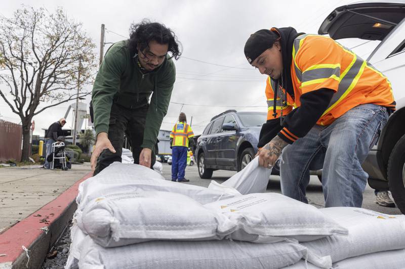 Fernando Bizarro, left, collects sandbags from an emergency centre to prepare for the coming storm. San Francisco Chronicle / AP