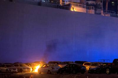 DUBAI. UNITED ARAB EMIRATES, 04 AUGUST 2017. A massive fire rips through The Marina Torch tower's southern corner. Flaming debris falls in an adjacent informal car park next to the building setting parked cars on fire. (Photo: Antonie Robertson) Journalist: None. Section: National.