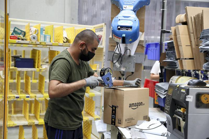 DUBAI, UNITED ARAB EMIRATES , March 18, 2021 –  Worker packing the box for delivery at the Amazon DXB3,  Amazon fulfilment centre in Dubai Logistics City in Dubai. (Pawan Singh / The National) For Lifestyle/Online/Instagram. Story by Farah