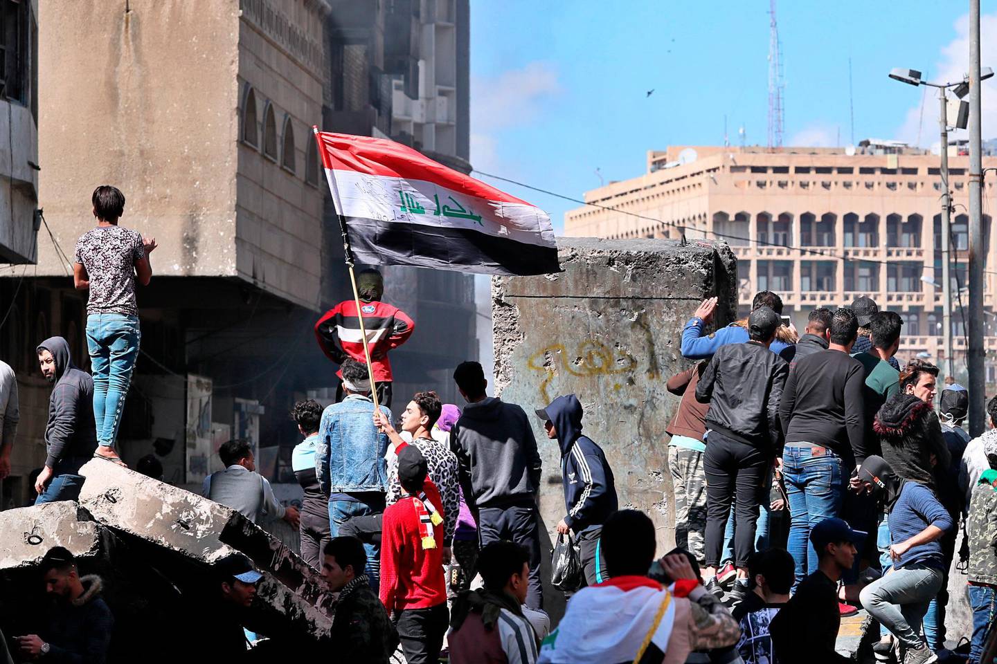 Protesters gather at barriers that block the protest site, in Baghdad, Iraq, Monday, March 2, 2020. (AP Photo/Hadi Mizban)