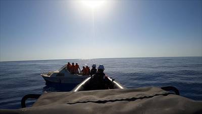 A rescue team approaches migrants on board of rubber dinghy at sea off the coast of Libya, August 22, in this still image taken from the video. Sea-Watch/Handout via Reuters