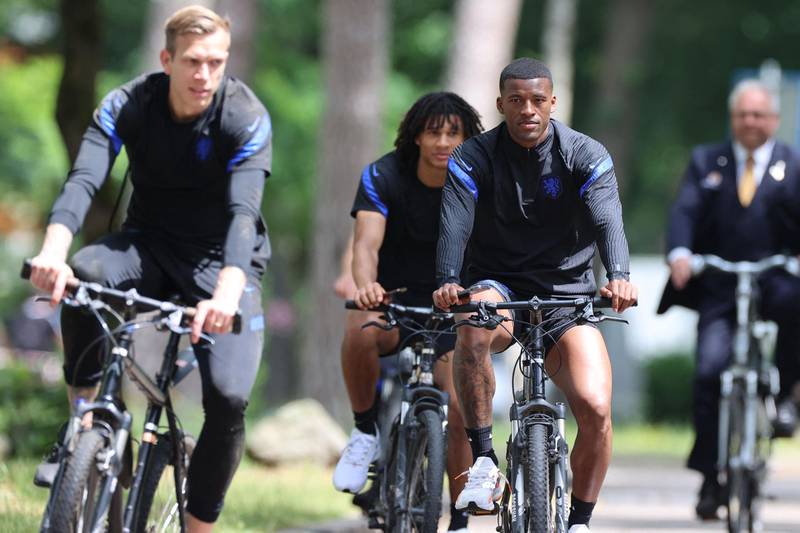 Georginio Wijnaldum (R) and teammates ride bikes following a training session in Zeist ahead of the Euro 2020 Group C match against North Macedonia. AFP