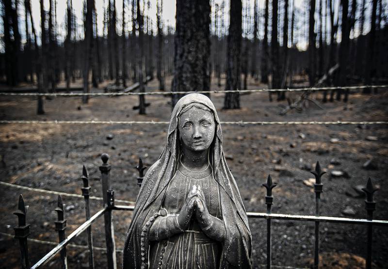 Blackened tombstones and statues stand at the Rociada Cemetery after fire tore through the area near Mora, New Mexico. Santa Fe New Mexican / AP