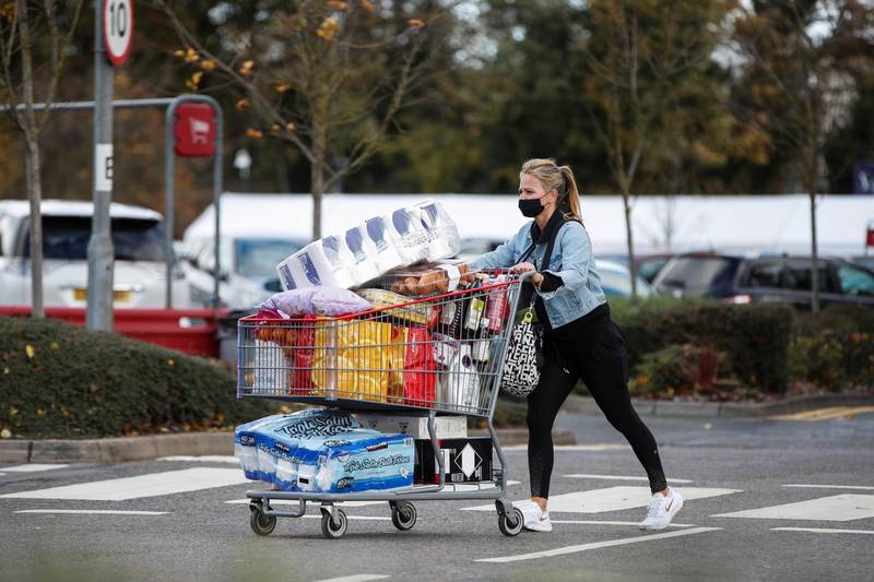 A woman pushes a full shopping cart outside a store in Watford after new nationwide restrictions were announced in England. Reuters