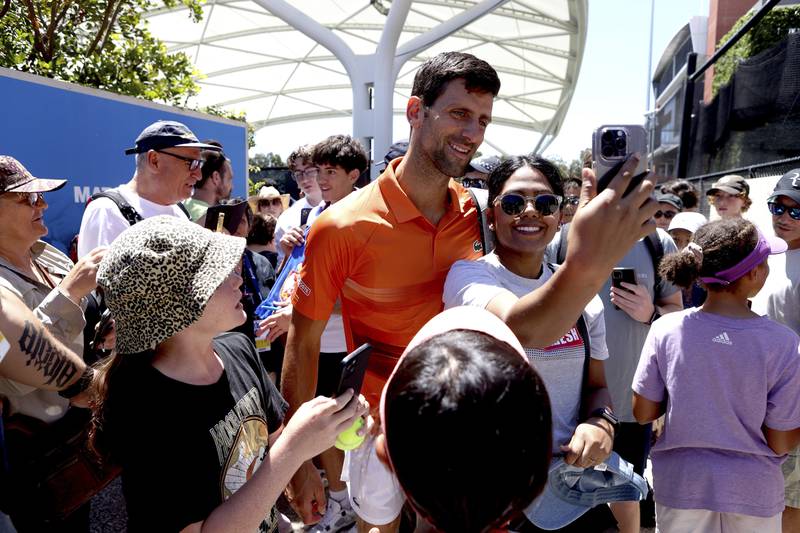 Serbia's Novak Djokovic, centre, poses for a selfie with a fan after his doubles match at the Adelaide International Tennis tournament in Adelaide, Australia, Monday, January  2, 2023. AP Photo