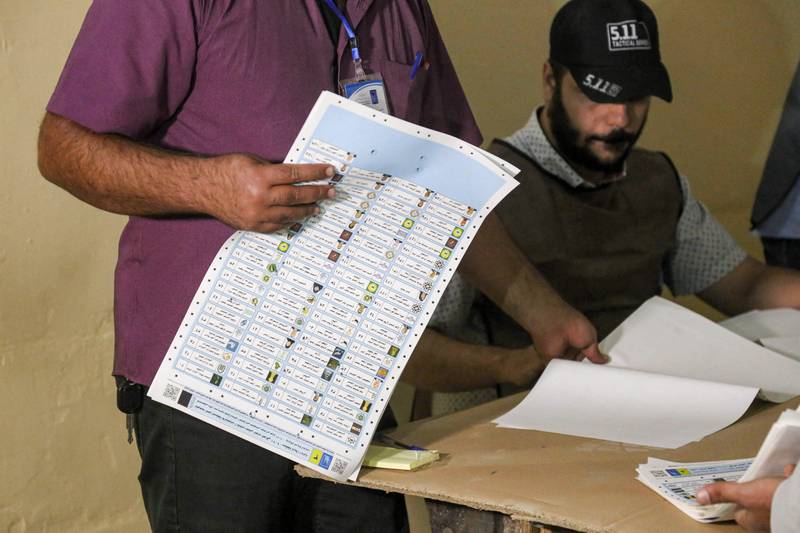 Iraqi election officials conduct a manual count of votes from a ballot box picked at random as part of the verification process for the electronic count, at a polling station in the central city of Karbala. AFP