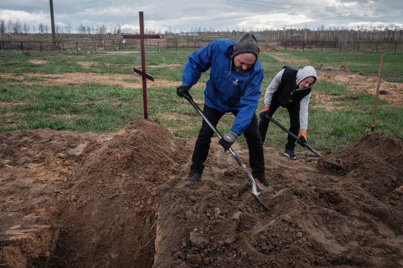 Residents bury two bodies in Bucha, north-west of Kyiv, where hundreds of people were found massacred. AFP