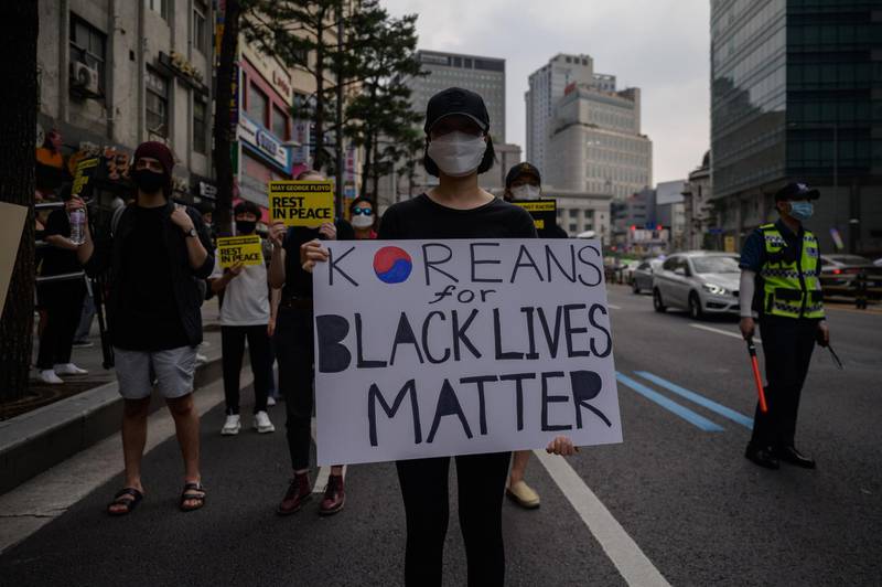 Activists hold placards as they attend a rally in support of the 'Black Lives Matter' demonstrations in the US, during a march in the Myeongdong district of central Seoul on June 6, 2020. AFP