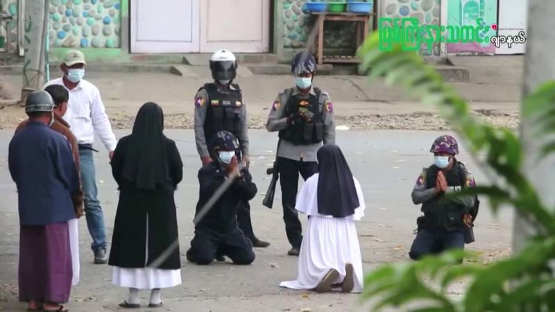 Myanmar nun Sister Ann Rose Nu Tawng kneels in front of police in protest against violence during anti-coup protests in Myitkyina, Myanmar. Two officers kneel in response. Reuters