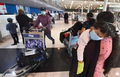 An Indian woman carries a sleeping child as she waits at the Dubai International Airport before leaving the Gulf Emirate on a flight back to her country, on May 7, 2020, amid the novel coronavirus pandemic crisis.  The first wave of a massive exercise to bring home hundreds of thousands of Indians stuck abroad was under way today, with two flights preparing to leave from the United Arab Emirates.
India banned all incoming international flights in late March as it imposed one of the world's strictest virus lockdowns, leaving vast numbers of workers and students stranded.

  


  
 / AFP / Karim SAHIB
